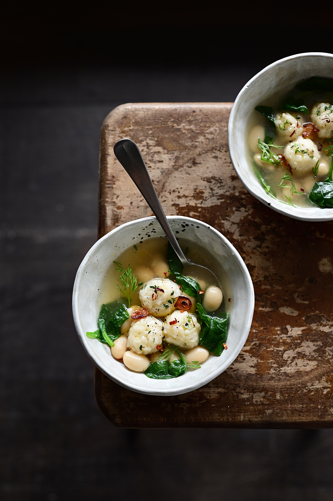 Parmesan rice ball soup with spinach and butter beans Serving dumplings
