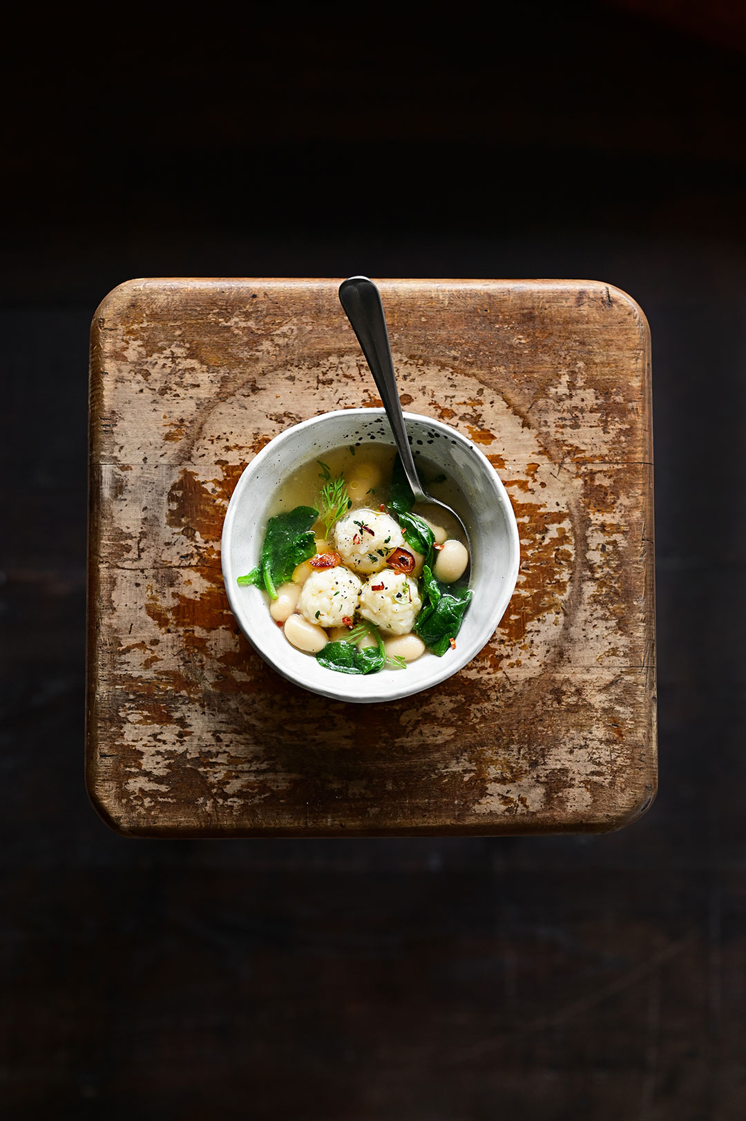 Parmesan rice ball soup with spinach and butter beans