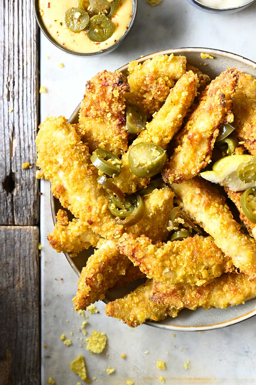 Krokante chicken fingers met nachos, jalapeños en aïoli